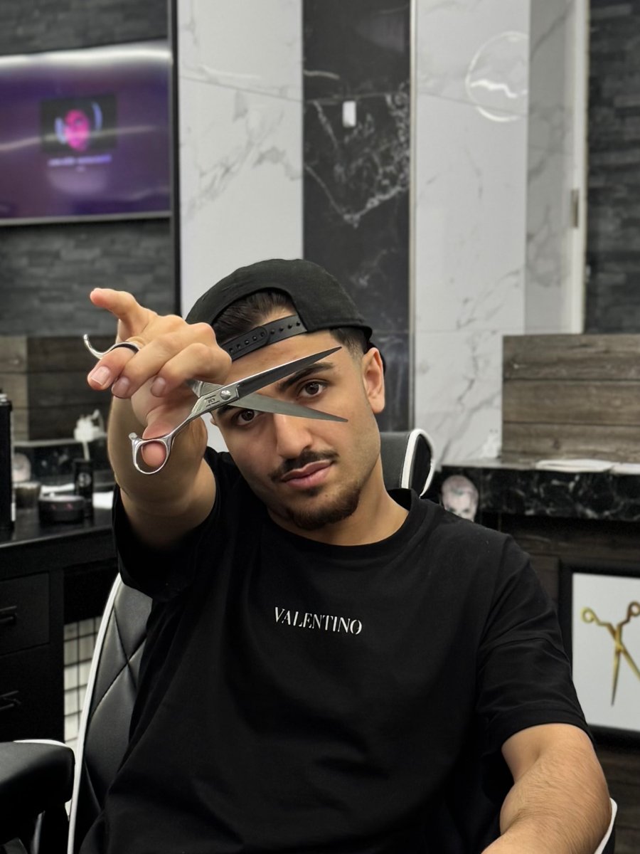 Ahmed mit Schere im Salon Coiffeur Momo