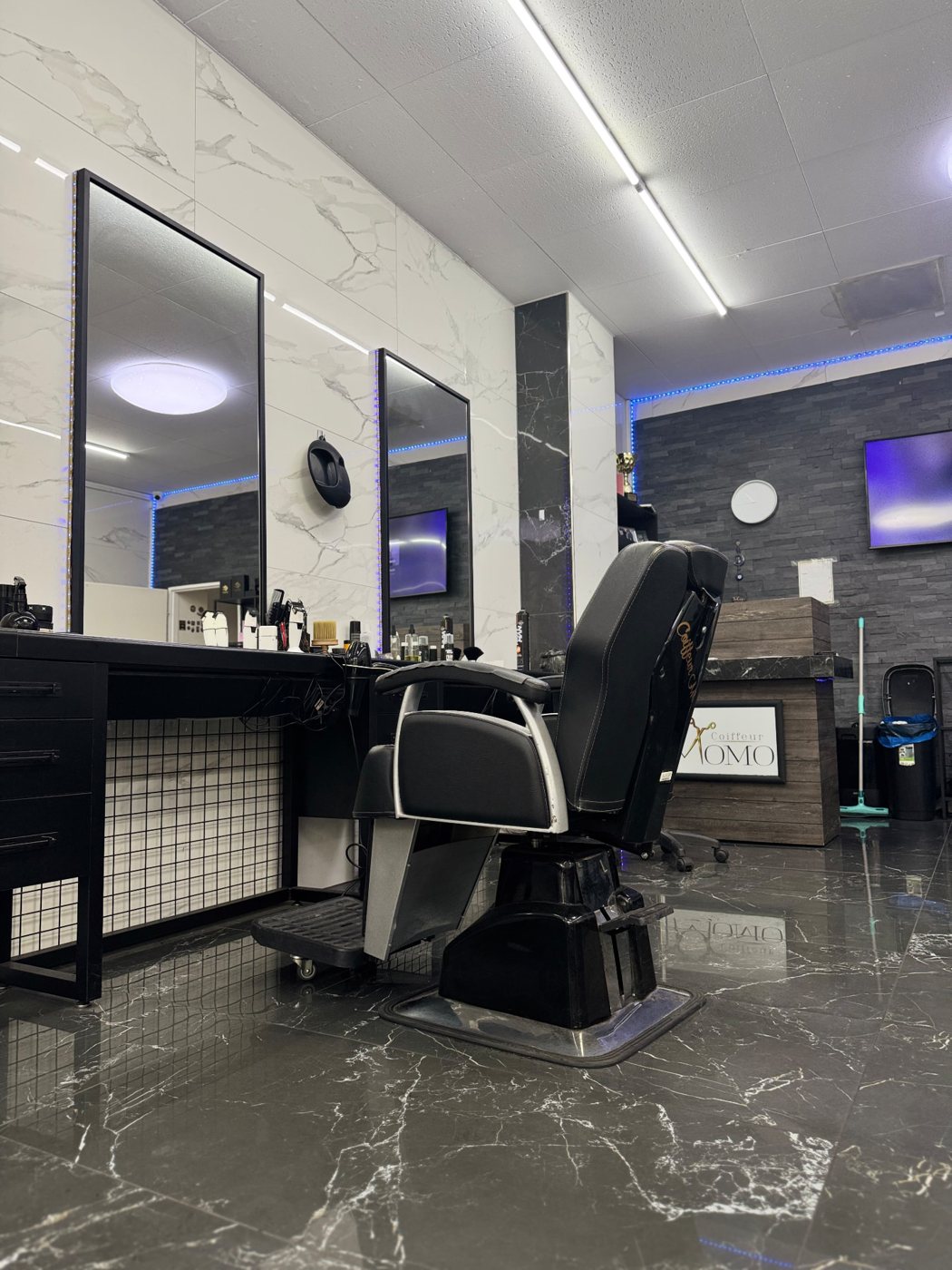 Barber-Stuhl vor Spiegeln und weissen Marmorwänden bei Coiffeur Momo